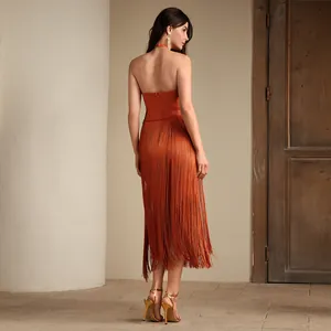 Detailansicht der Rückseite eines eleganten orangefarbenen Bandagekleids mit langen Fransen.