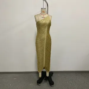 Full view of a glamorous gold one-shoulder fringe bandage dress displayed on a dress form