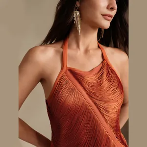 Detailansicht eines orangefarbenen Halterneck-Kleids mit langen Fransen und schmaler Passform.