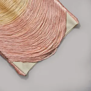 Detailansicht eines rosa Verlaufs-Bandage-Kleids mit langen, feinen Fransenquasten