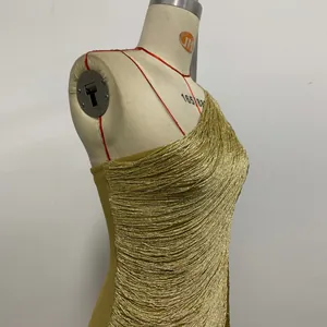 Detailed side view of a gold one-shoulder tassel bandage evening dress on a dress form