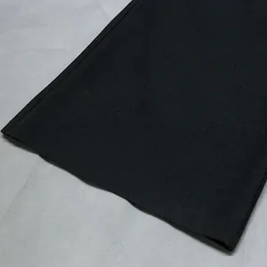 Primo piano della trama del tessuto nero premium e del dettaglio dell'orlo della tuta donna
