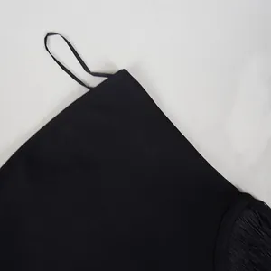 Close-up detail of a black strapless jumpsuit with fringe and soft fabric texture