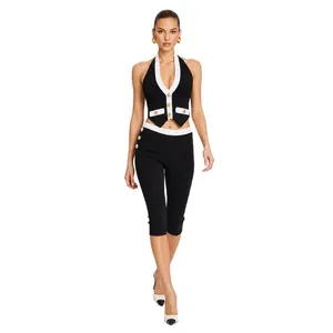 Elegante contrastrijke halter crop top en capri-broek set met gouden knoopdetails.