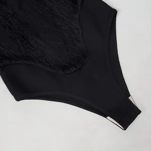 Close-up of black fringe patchwork and fabric texture on designer strapless bodysuit.