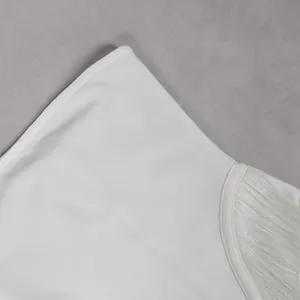 Macro view of white fringe jumpsuit detailing high-quality fabric and fine stitching
