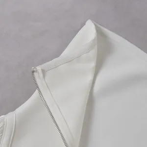 Close-up detail of smooth metallic zipper and textured fabric on white strapless jumpsuit
