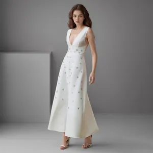 Elegante witte lange jurk met een diepe V-hals en verfijnde strass versieringen