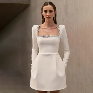 Elegante mini abito bianco con scollo quadrato e raffinato bordo di fiori di cristallo.