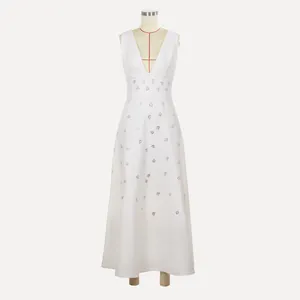 Gedetailleerd overzicht van witte maxi-jurk met diepe V-hals en fonkelende strass-bloemen