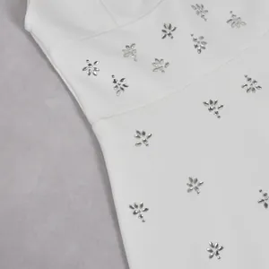 Close-up van de fonkelende strass-patronen op een elegante witte nauwsluitende jurk