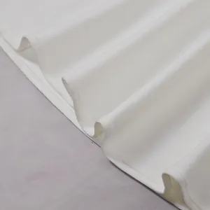 Detailopname van de gladde witte stofplooien en textuur van een elegante maxi-jurk