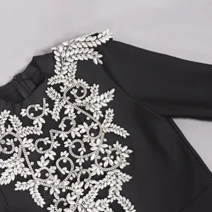 Nahaufnahme des silbernen Strass-Blumenmusters auf einem schwarzen Verbandskleid