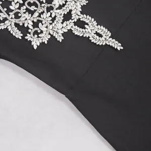 Detailansicht der filigranen silbernen Strass-Blattmuster auf einem schwarzen Bandage-Kleid