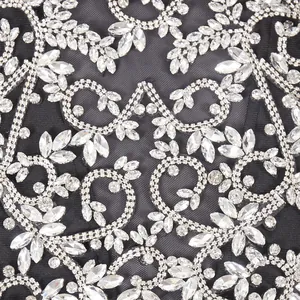 Nahaufnahme der luxuriösen klaren Strass-Stickerei auf schwarzem Mesh-Abendkleid