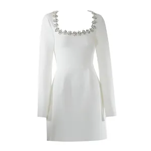 Vista dettagliata dell'elegante abito bianco con scollo quadrato e decorazioni di gemme