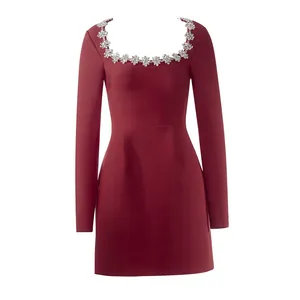 Dettaglio di un abito bordeaux elegante a maniche lunghe con scollo quadrato e strass lucidi