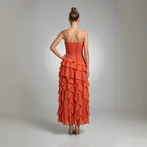 Elegante vista trasera del vestido largo de gasa naranja con volantes sin tirantes