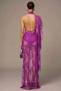 Back view of a purple floral lace maxi dress with halter neck and backless design