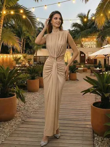 Vestido largo beige sin mangas con cuello alto y detalle de nudo en café de jardín