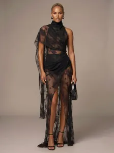 Full length view of a sexy black sheer floral lace maxi dress with asymmetric draped cape