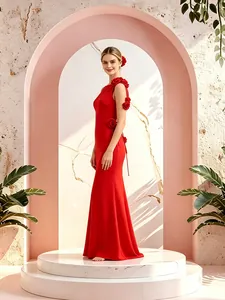 Elegante vestido de sirena rojo con detalles florales en 3D sobre pedestal de mármol