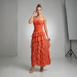 Vista detallada de un vestido de gasa naranja sin tirantes con volantes y cintura plisada