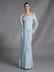 Detalle de vestido de noche azul claro con hombros descubiertos y cintas