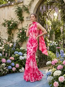 Elegante vestido largo con estampado floral rosa y bufanda fluida en un jardín real