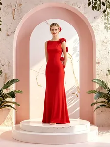 Vista detallada de vestido largo rojo ajustado con elegantes adornos florales en el hombro