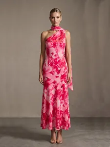 Detalle de elegante vestido largo con estampado floral rosa y bufanda de cuello a juego.