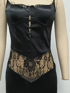 Close-up of elegant black satin slip dress with intricate floral lace patchwork details