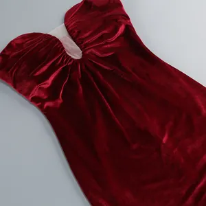 Detalle de un vestido palabra de honor en terciopelo granate con elegante malla plisada