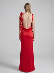 Vista trasera detallada de un elegante vestido largo rojo sin espalda con flores 3D en el hombro