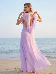 Elegant lavender backless maxi dress with ruffled detailing shown at a beach sunset.
