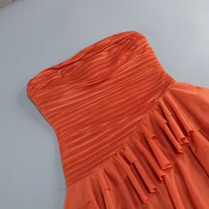 Primer plano del vestido de gasa naranja sin tirantes con pliegues elegantes