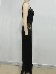 Side view of an elegant black satin slip dress with delicate floral lace patchwork details.