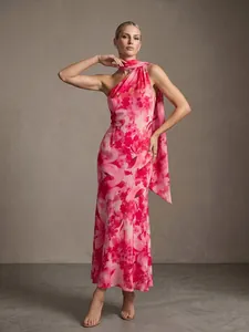 Detalle de vestido largo floral rosa con pañuelo elegante al cuello y silueta entallada
