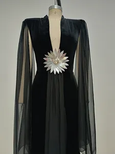 Detalle de un elegante vestido de noche de terciopelo negro con escote en V y malla