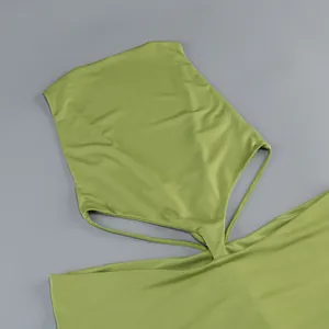 Detalle del vestido halter verde aguacate con aberturas y textura de tela sedosa.