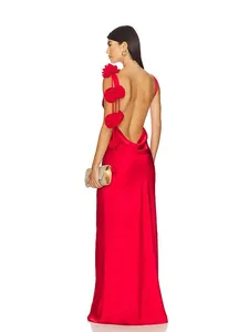 Detalle del vestido de fiesta rojo de satén con espalda abierta y flores 3D aplicadas.
