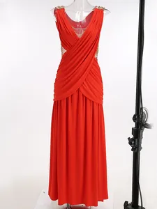 Detalle de vestido largo rojo con cuello en V y tirantes de cadena dorada