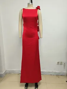Detalle de un elegante vestido largo de satén rojo con flores en 3D en el hombro