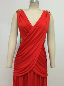 Detalle de vestido rojo con cuello en V cruzado y cadenas doradas en un maniquí
