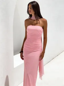 Primer plano de un elegante vestido largo rosa palabra de honor con abertura y cinta de seda