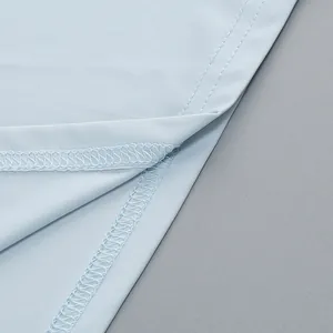Detalle macro de las costuras finas y el tejido azul claro liso del elegante vestido