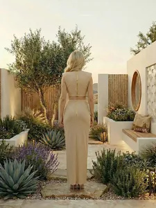 Vista trasera de elegante conjunto de vestido largo beige de dos piezas con cremalleras