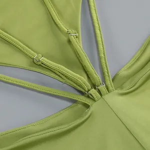 Primer plano de los ajustadores metálicos en el vestido verde con diseño calado.