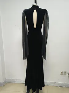 Elegante vestido largo de terciopelo negro con mangas de malla y un diseño de espalda descubierta