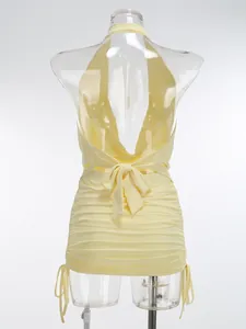 Detalle de la vista trasera de un vestido halter amarillo con lazo y pliegues fruncidos.